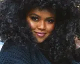 A woman with voluminous, natural curly hair, showcasing beautiful hairstyles for natural curly hair.
