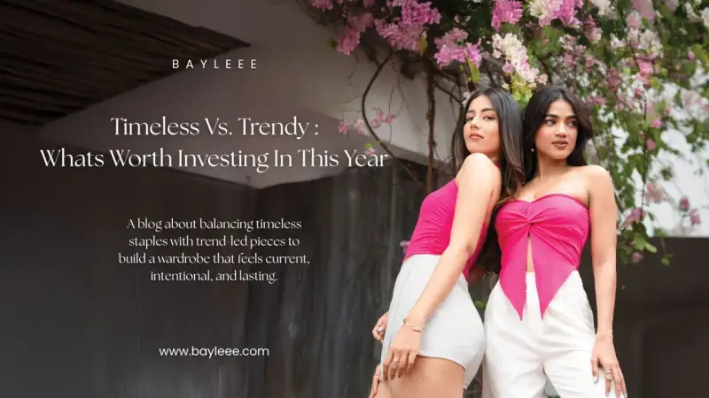 Two women showcase modern fashion couture, one in a pink tube top and white shorts, the other in a pink knotted top and white pants, against a backdrop of pink flowers.